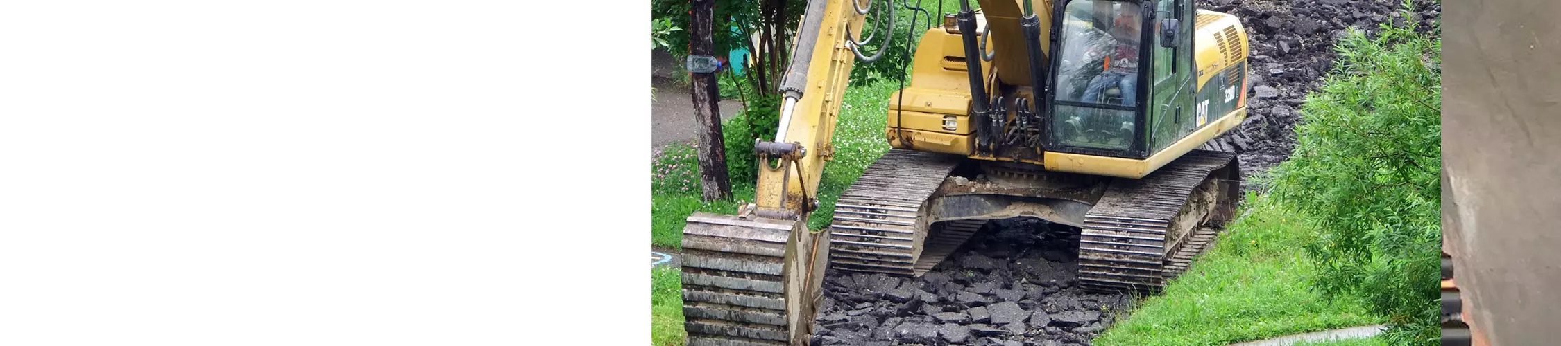 excavator digging up asphalt